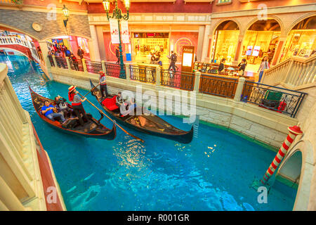 Macau, China - Dezember 9, 2016: Gondolieri mit Touristen auf einer Fahrt mit der Gondel auf dem Canal des Venetian Casino. In Luxus Shopping Mall im Venetian Hotel, Cotai Strip. Stockfoto