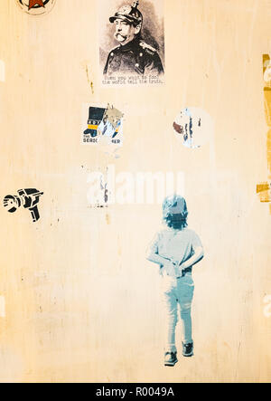 Wand mit stencil Graffiti und Aufkleber abgedeckt Stockfoto
