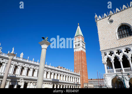 San Marco Glockenturm und Lion staue auf Spalte, nationalen Marciana Bibliothek und Dogenpalast Weitwinkelaufnahme, Clear blue sky in Venedig, Italien Stockfoto
