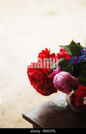 Reich Blumenstrauß auf dem Tisch in rot Palette Stockfoto