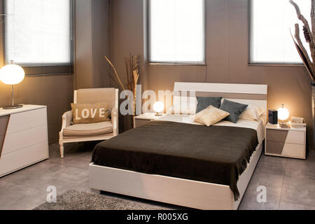 Romantische braun luxuriöse Schlafzimmer mit Sofa Bett und Stuhl mit Liebe Kissen mit runden Lampen beleuchtet