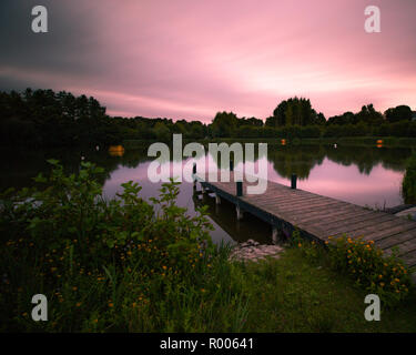 Einen Holzsteg an einem See bei Sonnenuntergang Stockfoto