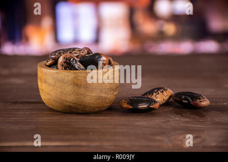 Menge ganze gesprenkelte Farbige butter Bohnen Painted Lady Scarlet runner Sorte mit Holzschale mit Restaurant im Hintergrund Stockfoto