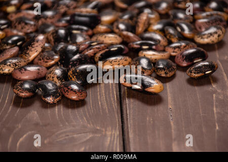 Menge ganze gesprenkelte Farbige butter Bohnen Painted Lady Scarlet runner Vielfalt auf braunem Holz Stockfoto