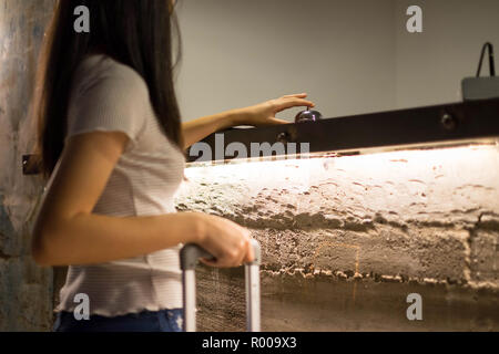 Close up Frauen rufen Sie das Hotel an der Rezeption auf dem Schreibtisch mit dem Finger drücken Sie eine Glocke in der Lobby Hotel. hotel Konzept. Stockfoto