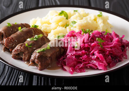 Deutsches Rindfleisch rouladen Rezept, zusammen mit Kartoffelpüree und Rotkohl close-up auf einem Teller. Horizontale Stockfoto