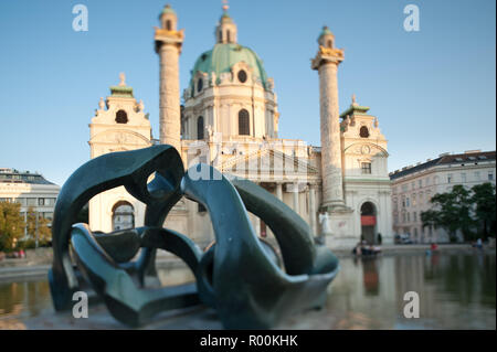 Wien, Karlskirche und Plastik' Hill Arches' von Henry Moore - Wien, Kirche St. Charles und Skulptur' Hill Arches" von Henry Moore. Stockfoto