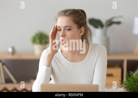 Müde Frau am Schreibtisch sitzen hat Kopfschmerzen Stockfoto