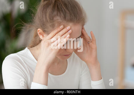 Nahaufnahme der frustrierten Frau bei der Arbeit sitzen Stockfoto