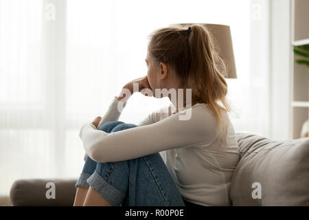 Verärgert Frau alleine zu Hause auf der Couch sitzen Stockfoto