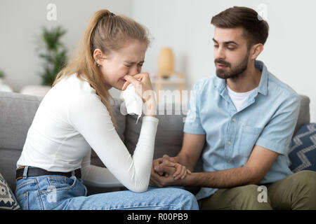 Frau weinend sitzen zusammen mit meinem Mann auf der Couch zu Hause Stockfoto