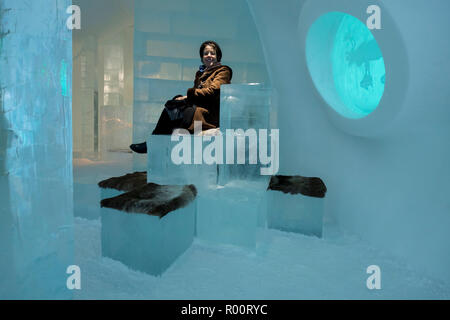 Ein Gast, der im berühmten Ice Hotel (Jukkasjärvi) in Kiruna, Schweden, Platz für Eisblöcke genießt. In der Lobby. Stockfoto