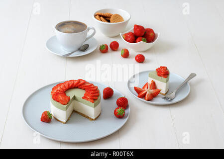 Kochen Demo. Nein - Backen zweischichtige Mini Erdbeere matcha Käsekuchen. Erdbeere Schichten schmücken die Oberseite des Kuchens. 3 Tassen mit Kaffee, Plätzchen und s Stockfoto