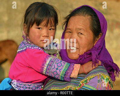 Ältere vietnamesischen Blume H'mong ethnische Minderheit Frau mit ihrer kleinen Enkelin. Stockfoto