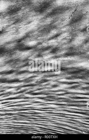 Abstraktes Bild von wasserwellen auf gekrümmten wider Betonoberfläche der Tunnel am Fluss entrahmt. Ripple Effect. Schwarzweiß-Version von R 00 TXB. Stockfoto