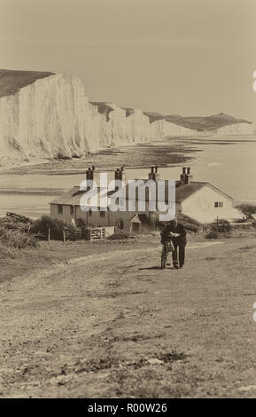 Die Seven Sisters Cliffs und der Cuckmere Haven Beach, vom Seaford Head Pfad aus gesehen, der an einer Terrasse mit Cottages der Küstenwache vorbeiführt. East Sussex. England. UK Stockfoto