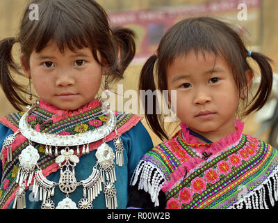 Zwei kleine vietnamesische Blume H'mong ethnische Minderheit Mädchen mit einem silbernen Halskette, gekleidet in farbenprächtige, bestickte traditionelle H'Mong Kleidung. Stockfoto