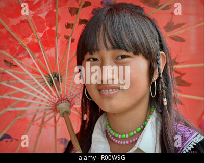 Vietnamesische H'Mong Jugendmädchen stellt unter einem handgefertigten traditionellen Öl- papier Sonnenschirm.