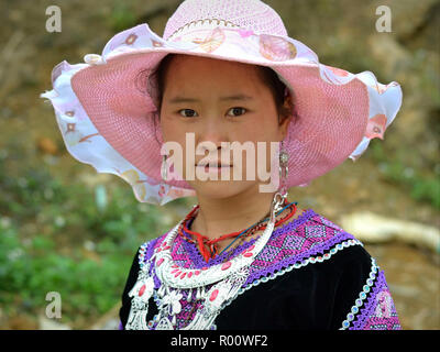 Vietnamesische H'Mong Jugendmädchen trägt eine elegante Sonnenhut in Rosa und tribal H'Mong Kleidung mit einem schweren Silber Halskette. Stockfoto