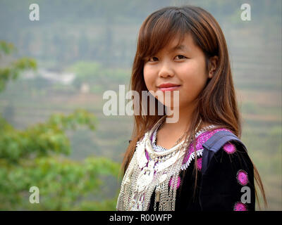 Ziemlich vietnamesischen H'Mong Jugendmädchen trägt traditionelle Ihres clan Outfit: bestickten schwarzen H'mong Bluse mit Silber tribal Kette. Stockfoto