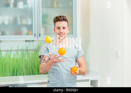 Junger Mann mit frischen Orangen jonglieren Stockfoto