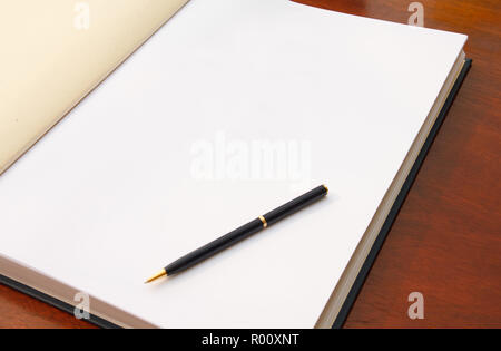 Große, offene Buch auf Holz Tisch mit weißen leere Seite und Stift. Bereit für Ihren Text. Stockfoto