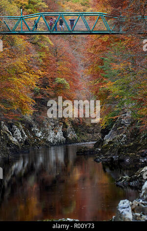 Touristen auf dem Grünen Fußgängerbrücke (Brücke von Garry) über den Fluss Garry am Pass von Killiecrankie im Herbst, Perthshire, Schottland. Stockfoto