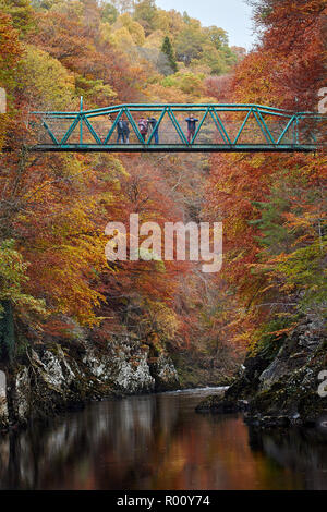 Touristen auf dem Grünen Fußgängerbrücke (Brücke von Garry) über den Fluss Garry am Pass von Killiecrankie im Herbst, Perthshire, Schottland. Stockfoto