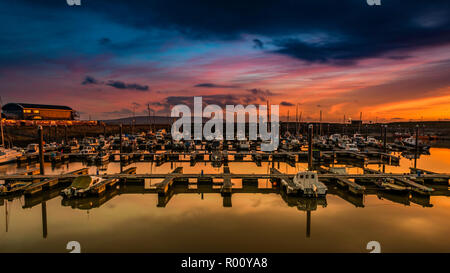 Sonnenuntergang Himmel bei Burry Port Docks. Boote im Wasser. Llanelli, Carmarthenshire, Wales. UK. Stockfoto