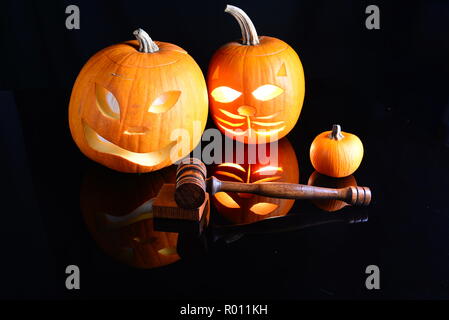 Geschnitzt und uncarved Kürbisse mit einer benutzerdefinierten hand Hammer plus Ton blockieren. Stockfoto