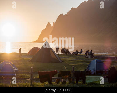 Strand Ersfjord Ersfjordstranden, Fjord, öffentlichen Erholungsgebiet, Sonnenuntergang, Menschen sitzen in Gruppen, Zelten, Camping, Blick auf die Bergkette Okshornan, ich Stockfoto