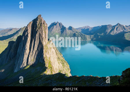 Berg Segla vom Berg Hesten gesehen, Peak Breidtinden in der Rückseite, kleines Segelboot auf dem ruhigen Siehe, Insel Senja, Troms, Norwegen Stockfoto