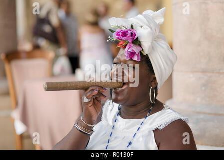 Theresa, eine fortunte Erzähler, stellt mit einem riesigen kubanische Zigarre und einem ansteckenden Lächeln in einer Plaza in Havanna. Stockfoto