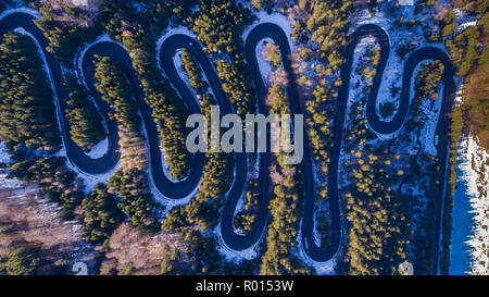 Geschwungene Straße durch den Wald. Pass in Siebenbürgen, Rumänien. Luftaufnahme von einer Drohne. Stockfoto