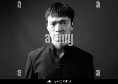 Studio shot junger chinesischer Mann in Schwarz und Weiß Stockfoto