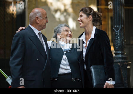 Mitte - Erwachsene business Frau mit ihrem älteren Mutter, die beiden umarmen sie und ihren Mann. Stockfoto