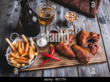 Fried Chicken Wings, Pommes frites, Nüsse, weiße und rote Sauce. Bier eingestellt Stockfoto