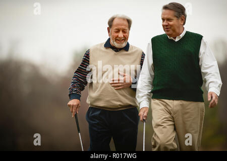 Zwei Männer, die Golf Clubs gehen und sprechen. Stockfoto