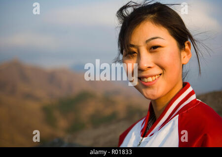 Porträt der jungen chinesischen Frau an der Großen Mauer von China. Stockfoto