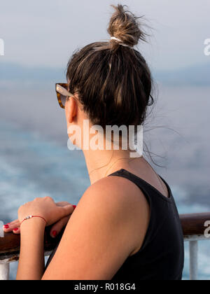 Junge Frau auf dem Schiff der Zaun mit Blick auf das Meer von der Rückseite Stockfoto