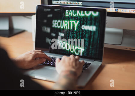 Mann bei der Arbeit am Laptop für Agile Scrum Prozess Sicherheitskonzept, hölzernen Tisch Stockfoto