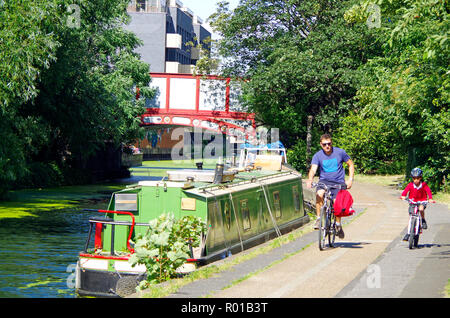 Vater und Sohn mit dem Fahrrad auf dem Leinpfad des Grand Union Canal in der Nähe von Harrow Road Bridge, London. Stockfoto