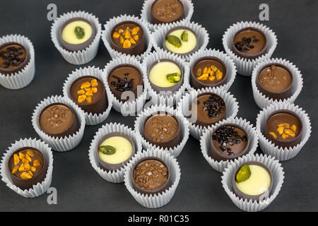 Bonbons Schokolade mit verschiedenen Füllungen in einem Papier wrapper auf einem hellen Hintergrund. Stockfoto