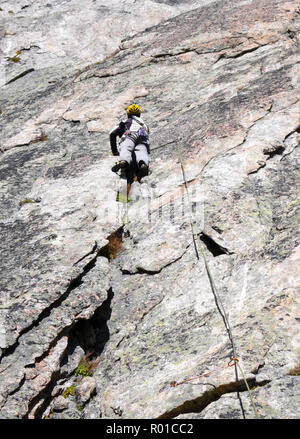 Bergführer Kletterer auf einem steilen Granit Route in den Alpen der Schweiz an einem schönen Tag Stockfoto
