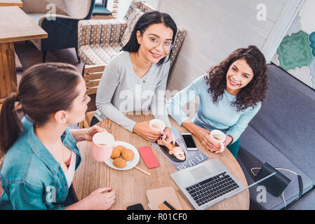Blick von oben auf die positive schöne Frauen am Tisch Stockfoto