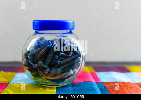 Jar voller Refill für Kugelschreiber auf einem bunten Tischdecke Stockfoto