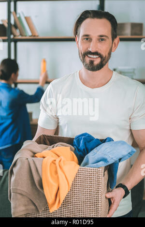 Gut aussehender bärtiger Mann seiner Frau zu helfen, Stockfoto