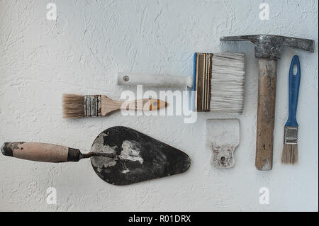 Kit von putty Messer. Spachteln mit der verbleibenden Mörtel. Gastarbeiter oder Gastarbeiter Konzept. Heimwerker. Werkzeuge für die Reparatur. Stockfoto