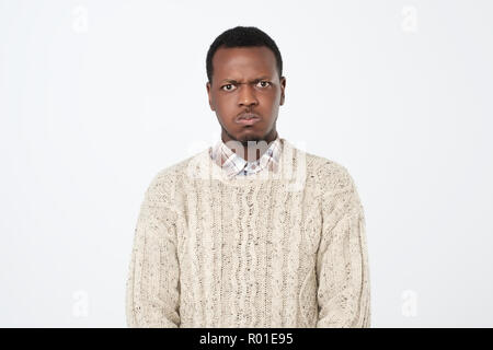 Afrikanischer Amerikanischer Mann in warmen Pullover an Kamera suchen mit schweren und traurigen Gesichtsausdruck gekleidet Stockfoto