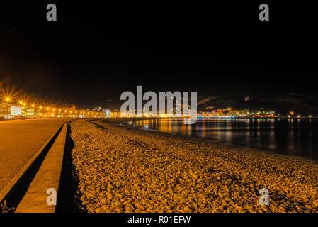 Ein Blick auf die Llandudno geschwungene Küstenlinie von White fronted Hotels in der Nacht gefüttert. Die Great Orme Landspitze liegt nur in der Entfernung und eine Nacht sichtbar s Stockfoto